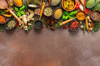 Canlı, taze kokulu baharat ve bitkilerden oluşan bir koleksiyon. Kahverengi bir arka planda renkli bir şekilde sergileniyor. Doğal ve aromatik güzelliklerini sergiliyorlar.