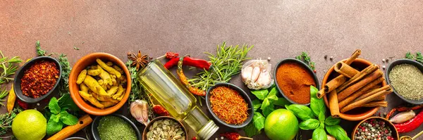 Kahverengi bir arka planda dinlenen renkli baharat ve otlardan oluşan zengin bir palet. Tazelik ve aroma yayıyor. Gurme ilham kaynağı ve afiş için mükemmel.