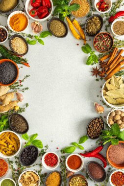 Gri üzerine çeşitli otlar ve baharatlardan oluşan canlı bir çerçeve, yemek pişirme ilhamı için canlı renkleri ve tatları vurguluyor, üst görünüm, kopyalama alanı