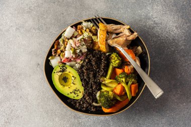 İçinde kinoa, avokado, kızarmış tavuk, patates, kabak ve brokoli gibi taze lahana ve turp salatası ile tamamlanmış kızarmış sebzeler bulunan besleyici, sağlıklı bir kahvaltı.