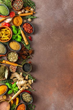 Baharat ve otların uyumlu bir karışımı, renkler ve kokularla dolu, kahverengi bir arka plana yayılmış, aşçılık sanatını çağrıştırıyor.