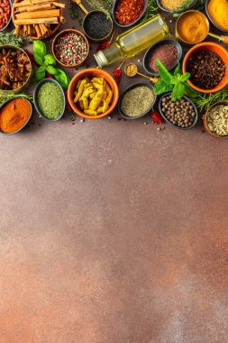 Sıcak kahverengi bir arka planda çeşitli kokulu bitkiler ve baharatlar, görsel çeşitliliklerini gösteren aromatik bir cazibe.