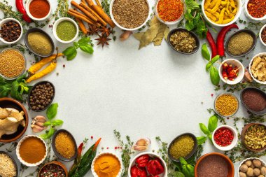 Taze ve renkli baharatlar ve bitkiler gri bir arkaplanda çerçevelenmiş, doğal güzellik ve mutfak cazibesi ekleyerek, üst görünüm, kopyalama alanı