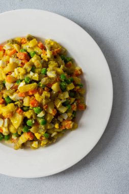 Bu renkli salata kaynamış yumurtaları, taze tavuk göğsünü, doğranmış patatesleri, canlı havuçları ve yeşil bezelyeleri birleştirir.