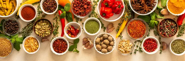 Değişik baharatlar ve kurutulmuş otlar bej bir zemin üzerine dizilmiştir. Mutfak çeşnisi ve aromatik, afişle zenginleştirilmiş yemekler için gereklidir.