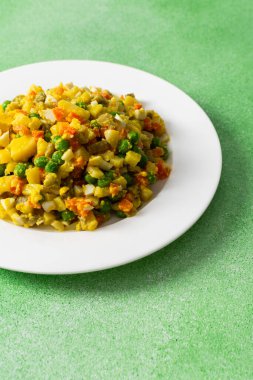 Canlı salata salataları haşlanmış yumurta, taze tavuk göğsü, doğranmış patates, tatlı havuç ve yeşil bezelye karışımı, hepsi zeytinyağı serpiştirilmiş, besleyici bir yemek kadar mükemmel.