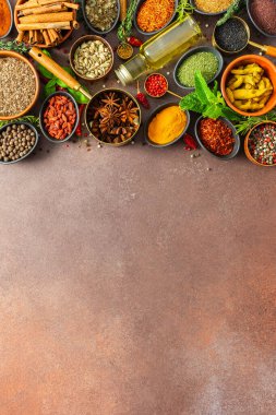 Sıcak kahverengi bir arka planda çeşitli kokulu bitkiler ve baharatlar, görsel çeşitliliklerini gösteren aromatik bir cazibe.