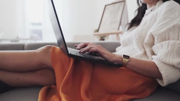 Una Mujer Está Sentada Sofá Usando Una Computadora Portátil Con — Vídeo de stock