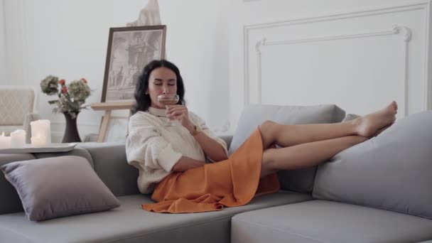 Una Mujer Está Descansando Cómodo Sofá Con Las Piernas Cruzadas — Vídeo de stock