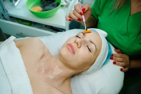 Güzellik kaplıcası sırasında yüzü gençleştirici bir maskeyle kaplanmış bir kadın yüzü..