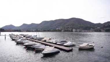 Huzurlu ve huzurlu bir yat limanı sahnesi. Birden fazla tekne, güzel bir göl kıyısına yanaştı.