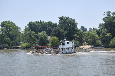 Tigre, Buenos Aires, Argentina, Jan 11 2022: Boat transporting debris on the Lujan river
