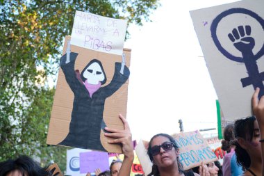 Buenos Aires, Arjantin; 8 Mart 2022: Uluslararası Kadınlar Günü. Afişler, biri feminist mücadelenin sembolü, diğeri de ölüm çizimi ve kızları yanıma almaktan bıkmış bir yazı..