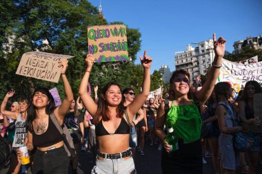 Buenos Aires, Arjantin; 8 Mart 2022: Uluslararası feminist grev sırasında yürüyen genç kadınlar, yaşamak istediğim metinle bir tabela tutan, hayatta kalmak değil.