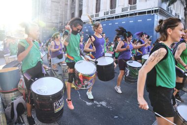 Buenos Aires, Arjantin; 8 Mart 2022: Uluslararası feminist grev; perküsyon enstrümanları çalan ve slogan atan bir grup genç kadın,.