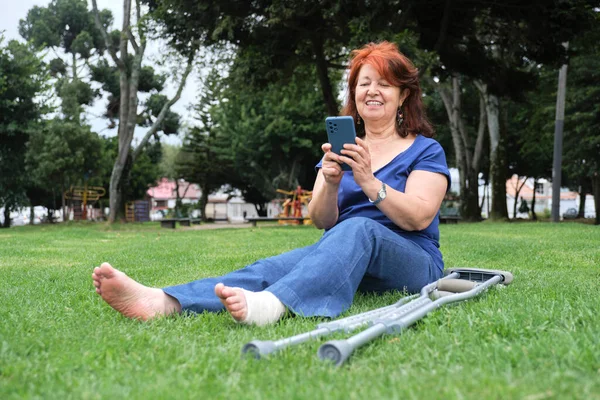 Mulher Latina Madura Descansando Grama Sorrindo Enquanto Usa Seu Smartphone — Fotografia de Stock