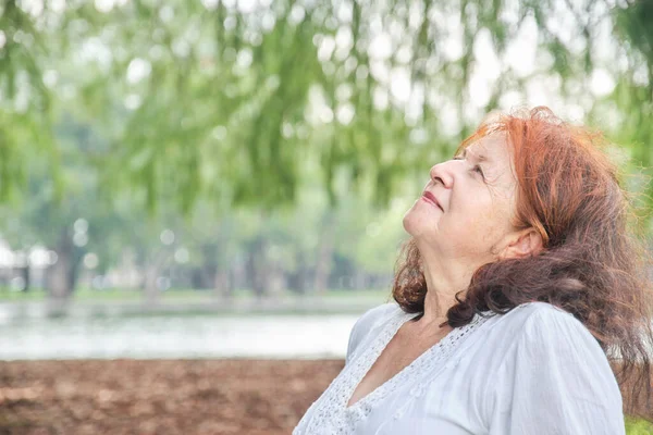 一个拉丁裔老年妇女的画像 面带微笑地看着大自然的白日梦 具有复制空间的明亮的作文 退休时心平气和地享受闲暇时间 — 图库照片