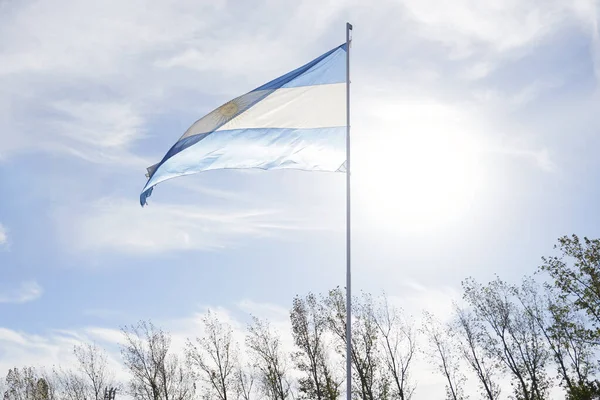 stock image Argentine flag waving on a flagpole outdoors, in a rural environment. Patriotic symbol of Argentina.