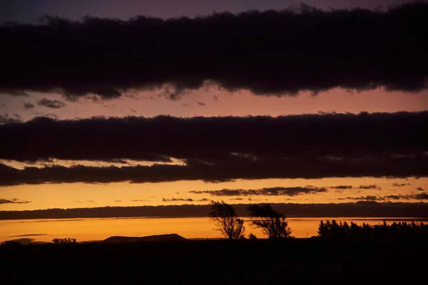 Ländliche Sonnenuntergangslandschaft Streifen Dunkler Wolken Und Klarer Himmel Verschiedenen Orangetönen — Stockfoto