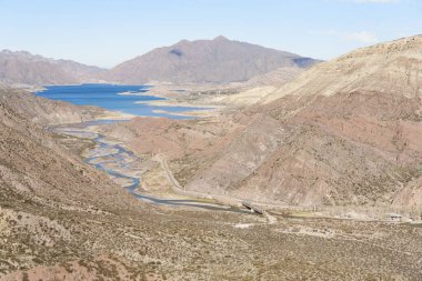 Arjantin 'deki And dağı manzarası, Mendoza nehri dağlar arasındaki bir vadiden geçer ve bir köprünün altından geçer..