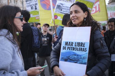 Buenos Aires, Arjantin, 5 Ekim 2023: Deniz aşırı petrol kullanımı için sismik keşfi protesto eden kadınlar, çevreci bir poster tutan kadın: Petrol şirketlerinden arınmış deniz.