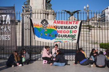 Buenos Aires, Arjantin, 5 Ekim 2023: İnsanlar, ulusal kongre önünde kıyı ötesi petrol sömürüsüne karşı bir mitingde. Poster: Çevre yanmış, iş güvenli. Çevre her şeydir..