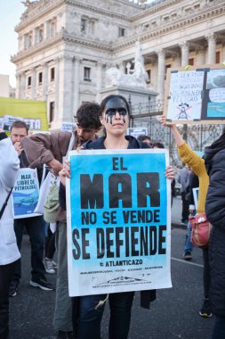 Buenos Aires, Arjantin, 5 Ekim 2023: Deniz aşırı petrol kullanımını protesto eden insanlar, elinde metni olan bir poster tutan kadın deniz satılık değil, savunuluyor..