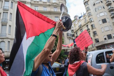 Buenos Aires, Arjantin, 16 Şubat 2024: Barış yanlısı posterler ve Filistin bayraklarıyla yürüyen insanlar Filistin ve İsrail soykırımına karşı dayanışma içinde.