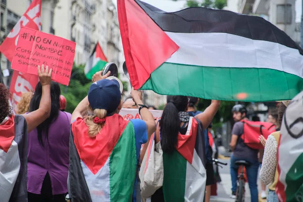 Buenos Aires, Arjantin, 16 Şubat 2024: Barış yanlısı posterler ve Filistin bayraklarıyla yürüyen insanlar Filistin ve İsrail soykırımına karşı dayanışma içinde.