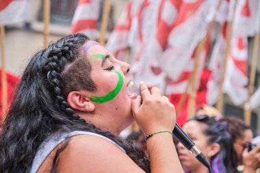 Buenos Aires, Arjantin; 8 Mart 2024: Uluslararası kadınlar grevdeyken gözleri kapalı feminist sloganlar atan genç bir kadının güçlü editoryal portresi.