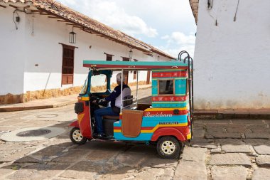 Barichara, Santander, Kolombiya; 25 Kasım 2022: Renkli mototaxi, Rickshaw, bu turistik şehirde şehir merkezindeki caddelerden geçen sıradan bir nakliye aracı..
