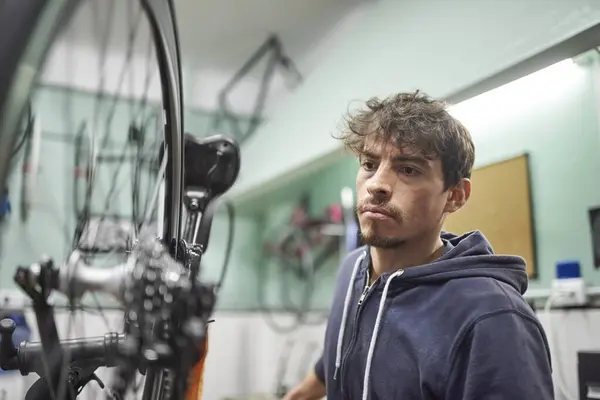 stock image Portrait of a latin bicycle mechanic working, assembling a bike at his repair shop as part of a maintenance service. Composition with selective focus. Real people at work.