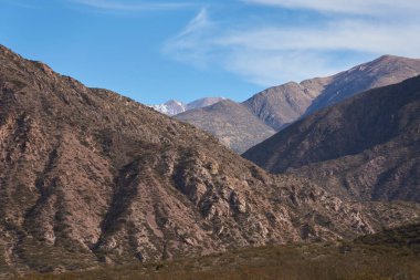 Güneşli bir sabahta dağlık arazi, Arjantin 'in Mendoza kentindeki Potrerillos Andean bölgesindeki dağ katmanlarının manzarası.