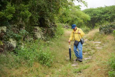 Santander, Kolombiya 'da, Barichara' dan Guane 'e giden, eski bir kraliyet yolunda yürüyen yaşlı Latin bir adam. Kavram: Doğayla temasta aktif emeklilik yaşam tarzı.