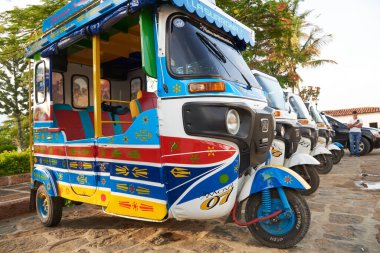 Guane, Santander, Kolombiya; 26 Kasım 2022: Bu renkli köyde turistleri bekleyen renkli motosiklet taksileri. Mototeksen, bu turistik bölgede yaygın bir nakliye aracı..