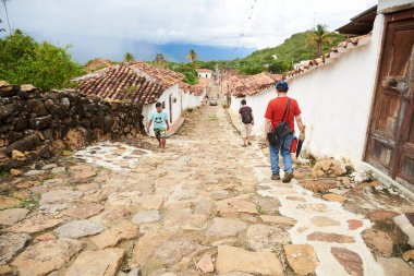 Guane, Santander, Kolombiya; 26 Kasım 2022: İnsanlar bu turist kasabasında sessiz bir koloni caddesinde yürüyor.
