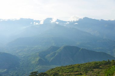 Kolombiya And Dağları manzarası, yemyeşil bitki örtüsü ve bulutlu güneşli bir gökyüzü. Guane, Santander 'daki bir gözcü noktasından bak.
