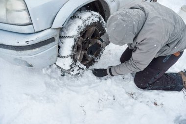 Kış zamanında, tanınmayan bir adam, bir SUV aracının tekerleklerine zincir takarak, bir dağ yolunda kar üzerinde ilerleyebilmek için seyahat eder..