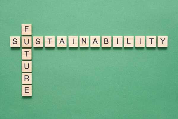Environmental crossword, wooden pieces with letters on a green background, associating the concepts of future and sustainability. A sustainable lifestyle is the key to the wellbeing of the planet.