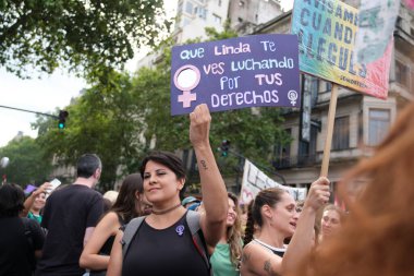 Buenos Aires, Arjantin; 8 Mart 2025: Uluslararası Kadınlar Günü. Elinde feminist bir mesaj taşıyan bir tabela tutan genç kadın: Haklarınız için savaşırken ne kadar güzel görünüyorsunuz..