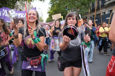 Buenos Aires, Arjantin; 8 Mart 2025: Uluslararası feminist grev; miting sırasında yürüyüş ve enstrüman çalarken gülümseyen bir grup kadın.