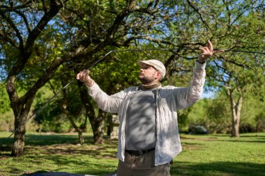 Çadırını doğal, sessiz, yeşil ve güneşli bir kamp alanına kuran bir adam..