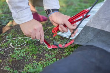 Kampta kurduğu çadırdan çadır kazığını yere çakan tanınmamış biri..