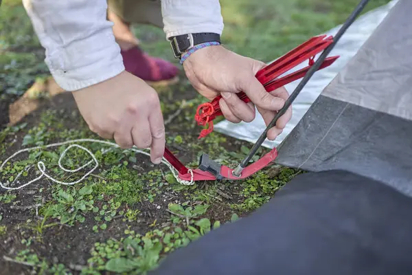 Kampta kurduğu çadırdan çadır kazığını yere çakan tanınmamış biri..