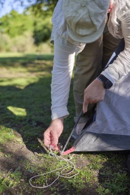 Tanınmayan bir adam çadırının direklerini kuruyor, onu dışarı kurarken..