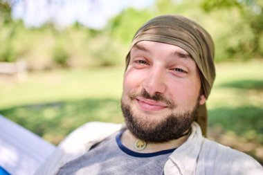 Genç bir İspanyol 'un portresi gülümseyen ve kameraya bakan hamakta rahatça oturan, dışarıda dinlenen. Dost canlısı ve neşeli birine benziyor..