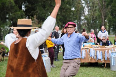 25 Mayıs 2025; Lobos, Buenos Aires, Arjantin: Ulusal bayramda geleneksel yemek, el sanatları ve müzikle yapılan bir kutlama olan Fiesta de la empanada sırasında halk müziği dansı yapan insanlar