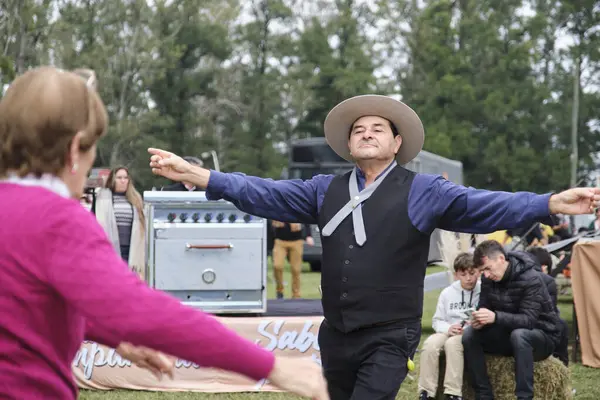 25 Mayıs 2025; Lobos, Buenos Aires, Arjantin: Ulusal bayramda geleneksel yemek, el sanatları ve müzikle yapılan bir kutlama olan Fiesta de la empanada sırasında halk müziği dansı yapan insanlar