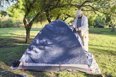 Çadırının yanında duran bir adam, Arjantin 'de vahşi bir kamp alanında kapatıyor..