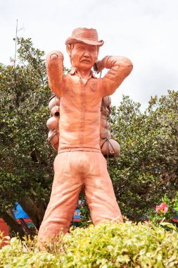 Raquira, Boyaca, Kolombiya; 29 Kasım 2022: Şehrin ana meydanında çömlekçiliğiyle tanınan bir zanaatkarın seramik heykeli.